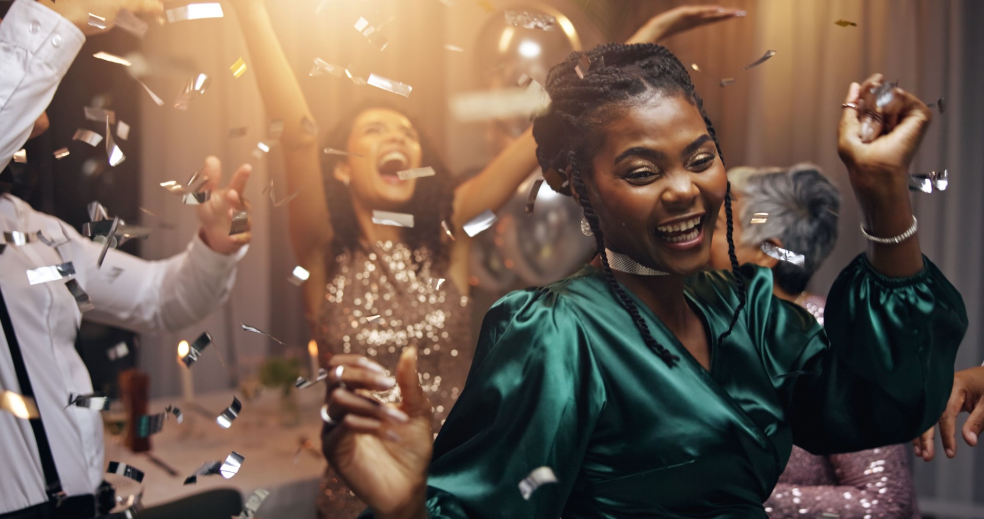 Woman, dancing and celebration at night, event and happy at new years eve with friends, diversity or colleagues. Business people, group and smile with confetti, glitter and excited for party at gala